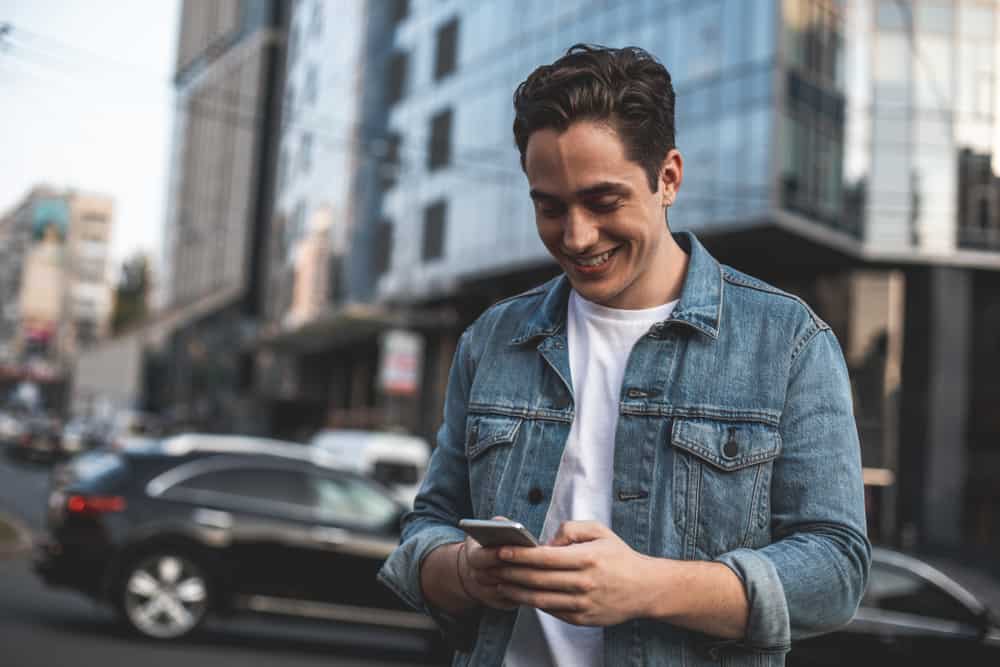un homme marche dans la rue et des boutons sur le téléphone