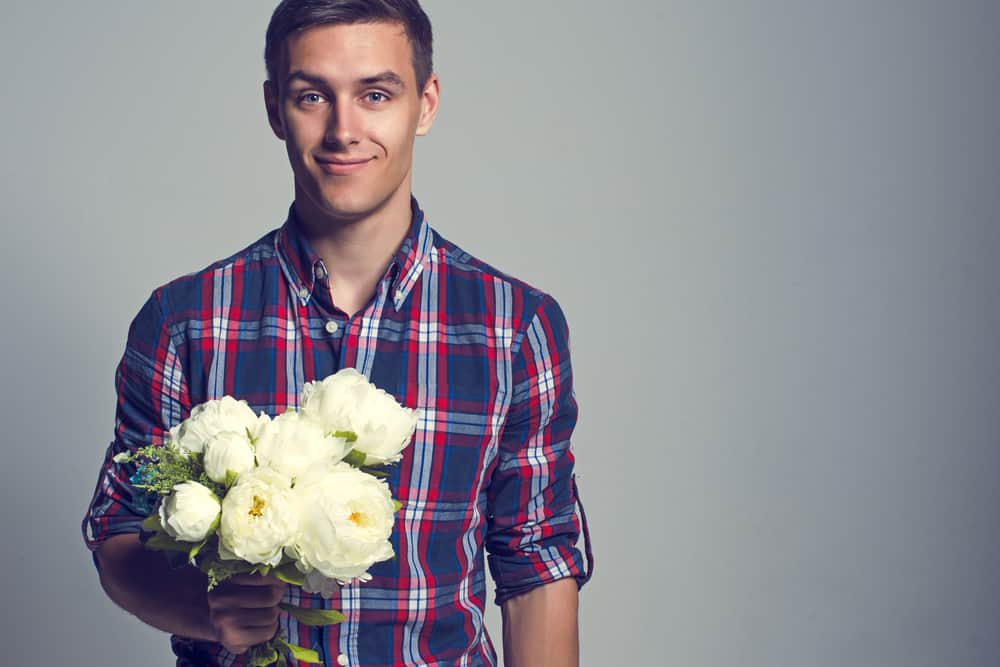 un homme tenant un bouquet de fleurs