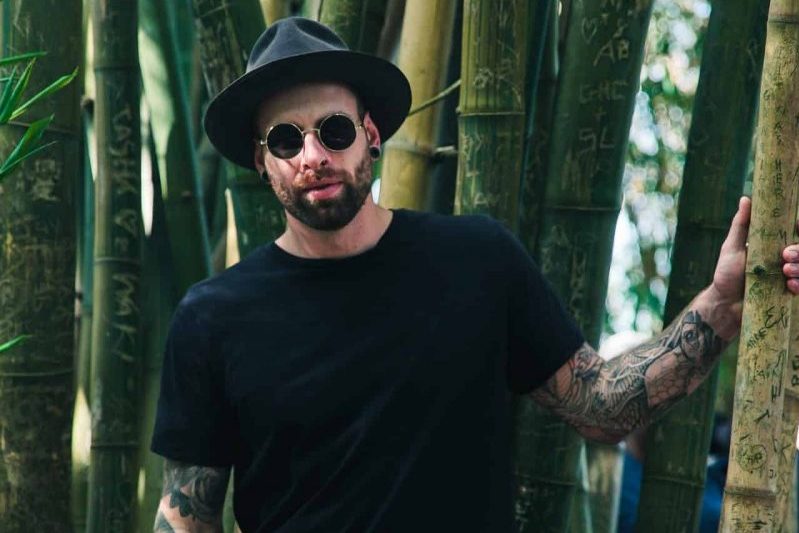 un homme à lunettes et un chapeau