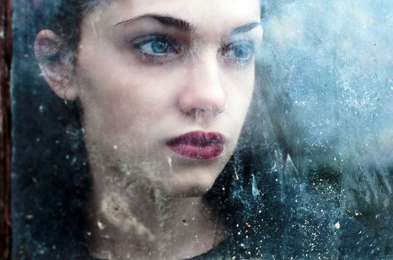 femme triste regardant par la fenêtre