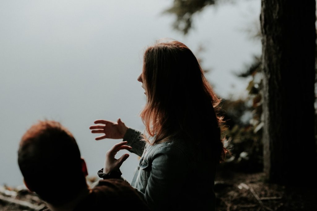un homme et une femme au bord de la rivière s'asseoir et parler