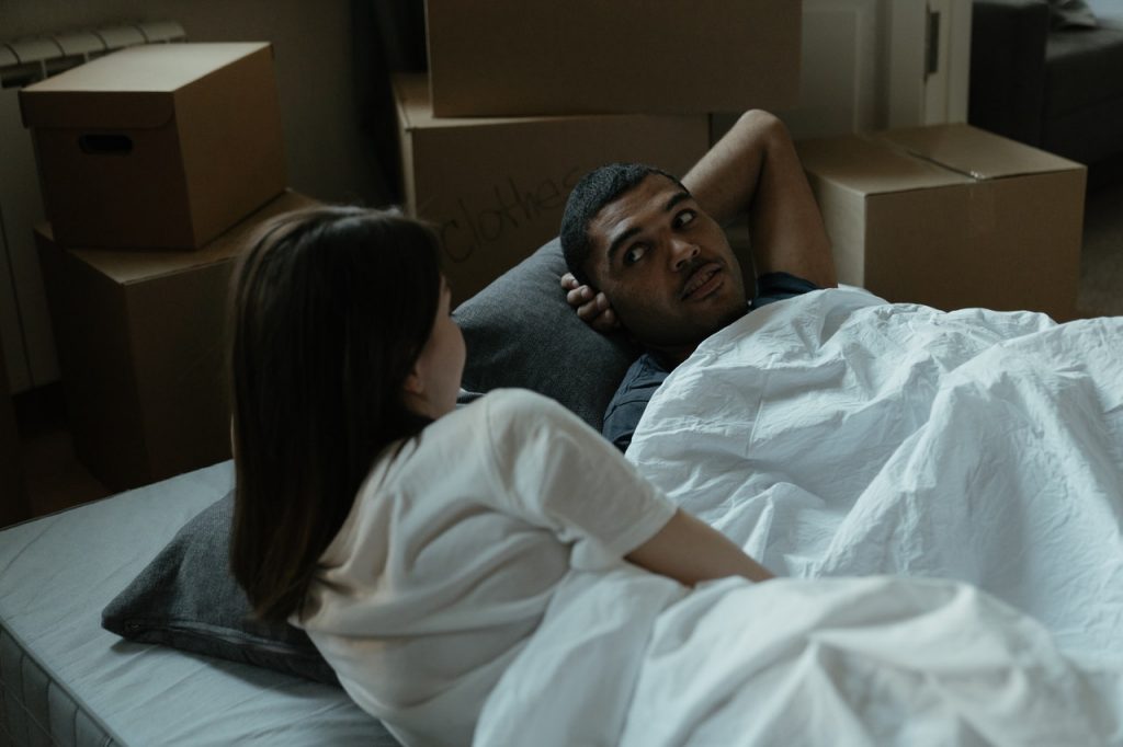 un homme et une femme parlant au lit