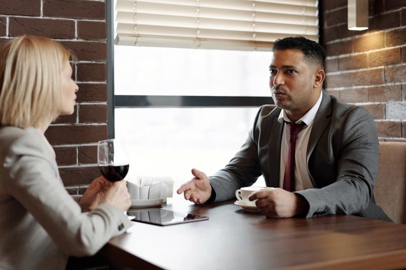 un homme et une femme sont assis face à face et parlent