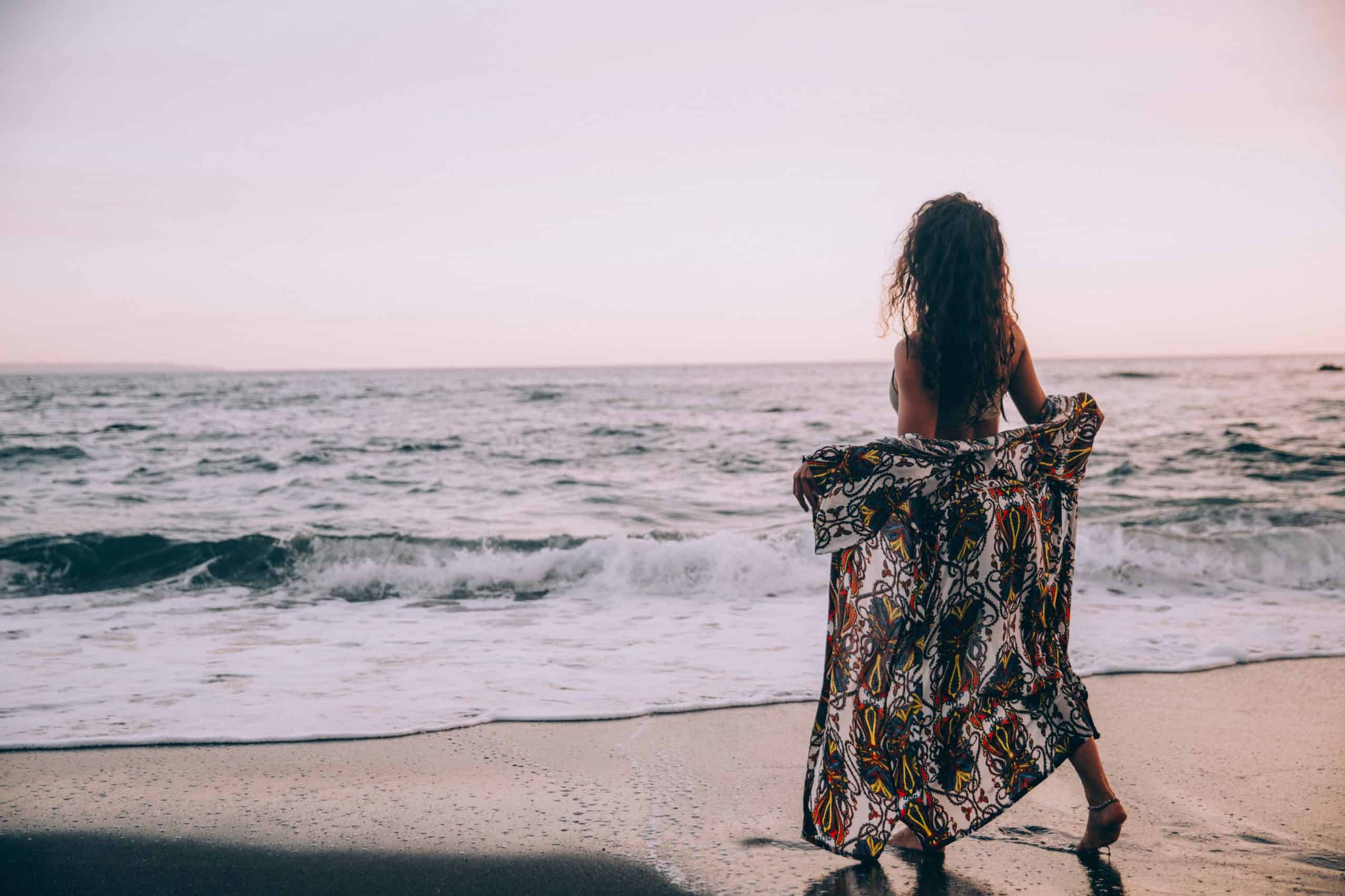 une femme enlève une couverture sur la plage