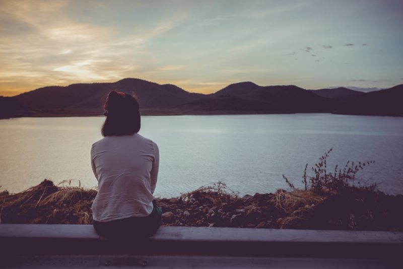 une femme est assise au bord de la rivière