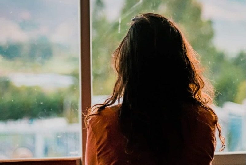 une femme regardant par la fenêtre