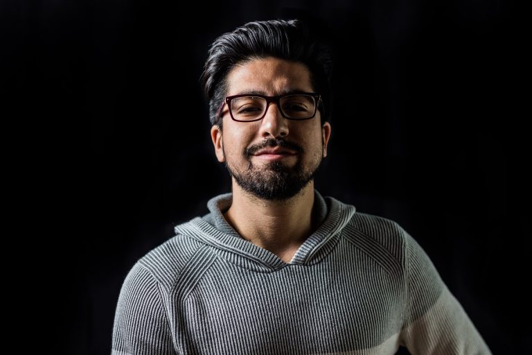 un homme aux cheveux noirs avec des lunettes