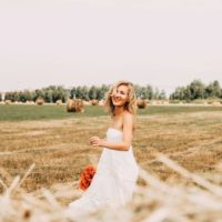 Une femme souriante dans un champ brun