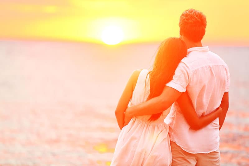 jeune couple, apprécier, les, coucher soleil, sur, plage