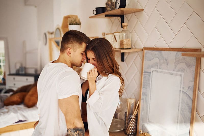 jeune couple, étreindre, dans, chambre à coucher