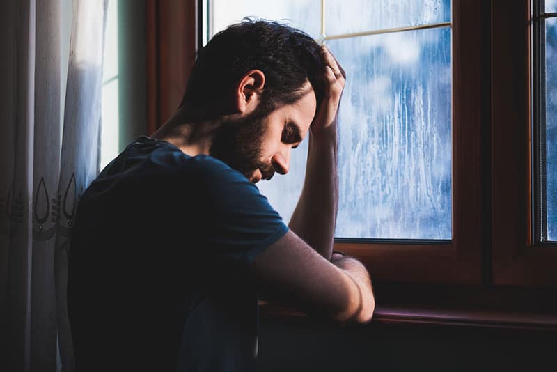 triste jeune homme près de la fenêtre