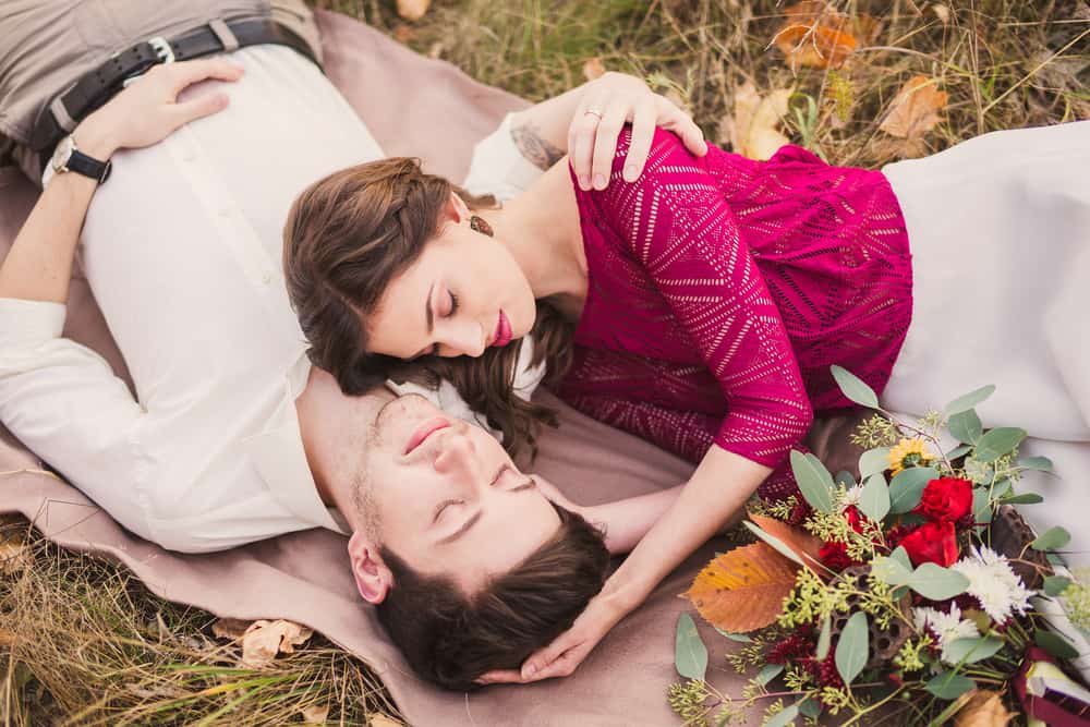 un homme et une femme allongés sur l'herbe