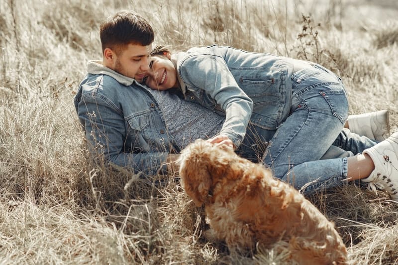 un homme et une femme se trouvent sur l'herbe embrassant