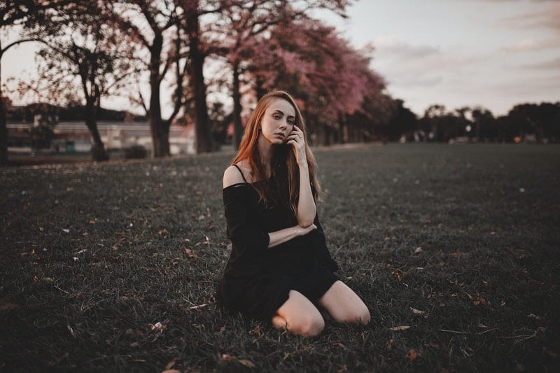 une femme agenouillée sur l'herbe