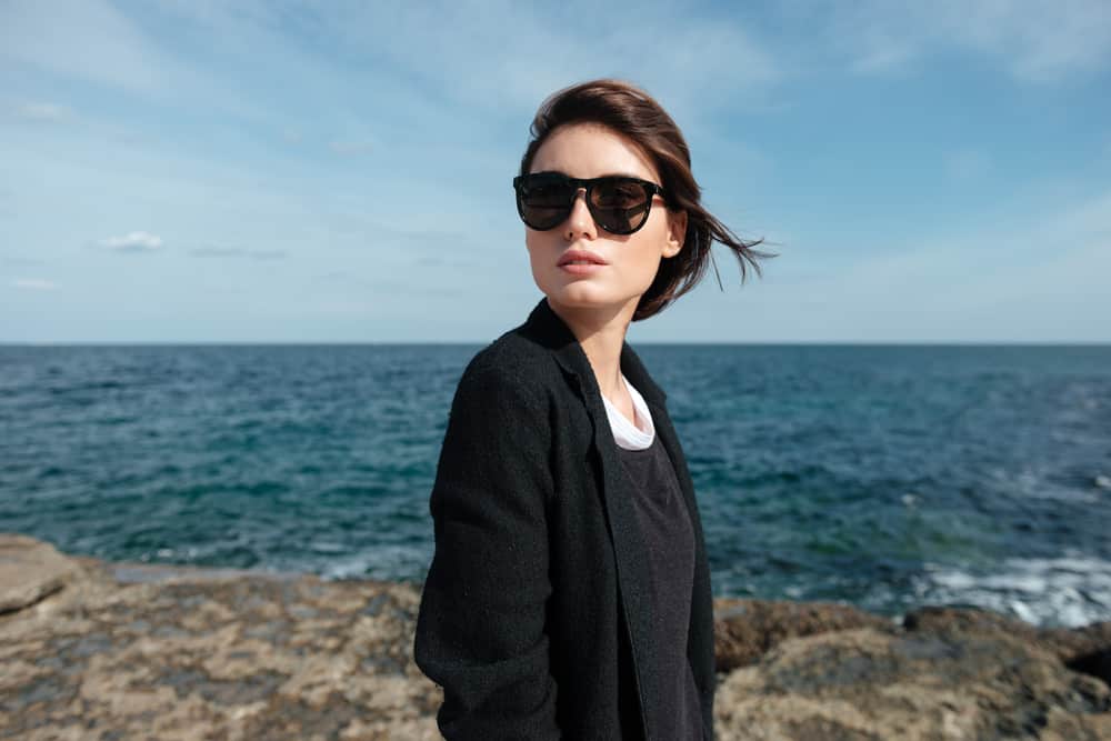 une femme avec des lunettes au bord de la plage