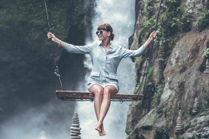 une femme est assise au-dessus d'une cascade