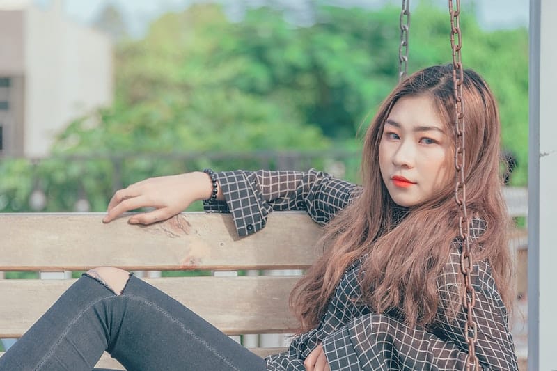 une femme sérieuse est assise sur un banc