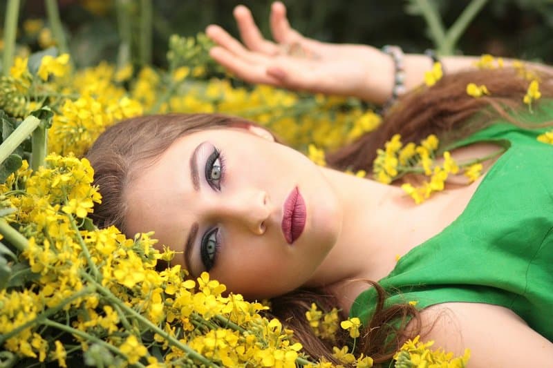 une femme sérieuse se trouve dans les fleurs