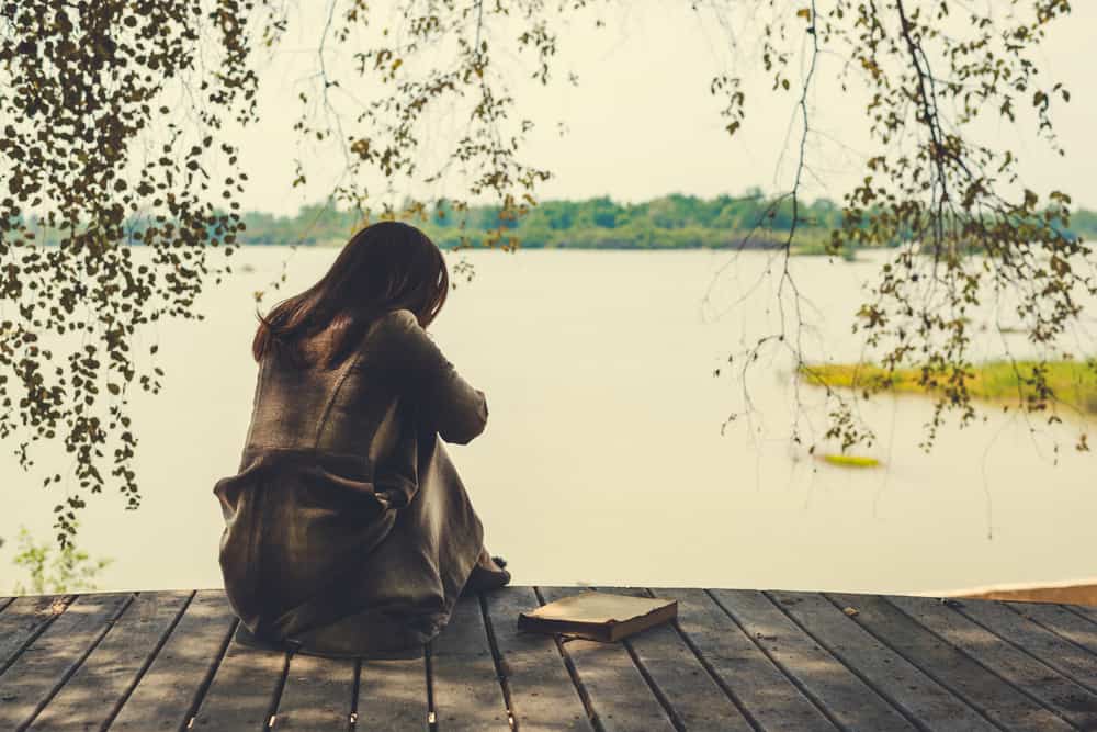 une femme triste assise sur la jetée