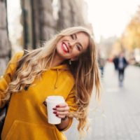 une femme blonde avec du café à la main