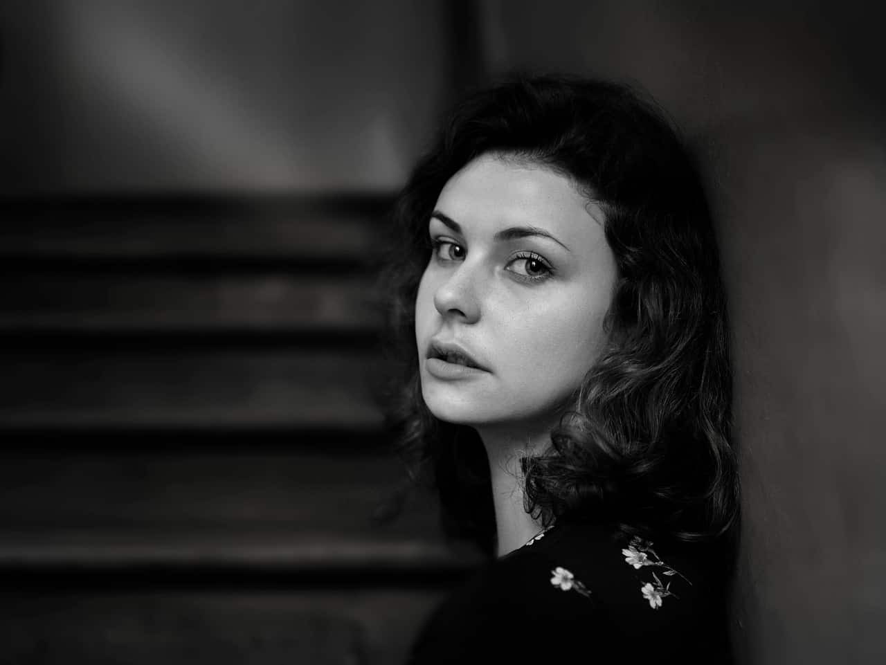 femme appuyée contre le mur à côté de l'escalier