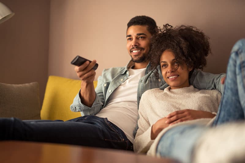 jeune couple afro-américain, regarder un film ensemble