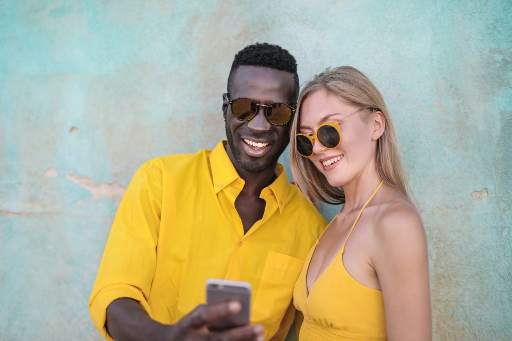 l'homme tient le téléphone dans sa main tandis que sa femme se tient à côté de lui