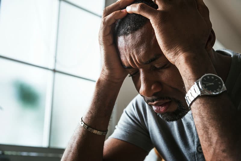 triste homme noir tenant sa tête