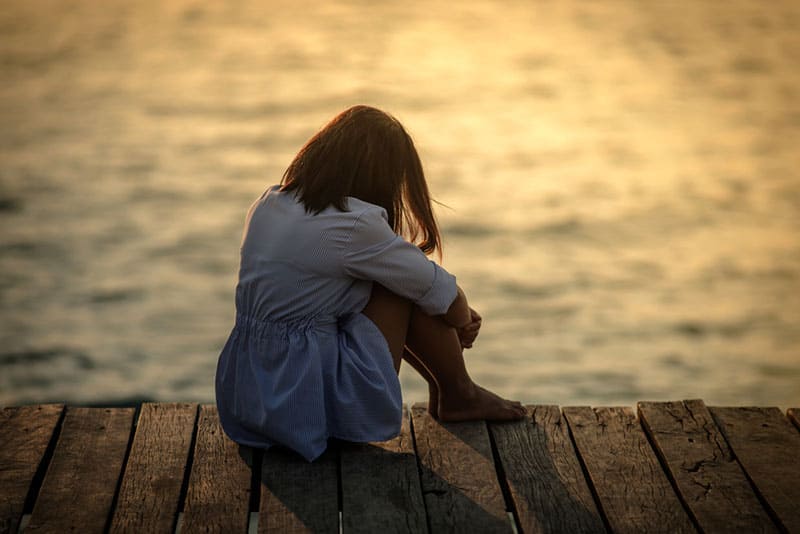 triste jeune femme assise sur le quai
