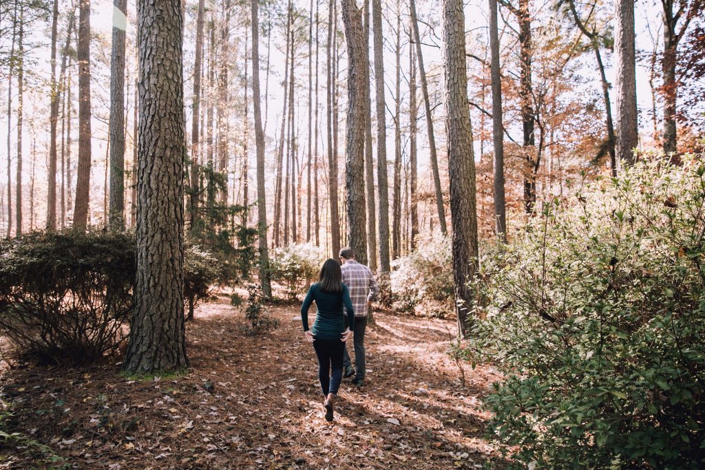 un homme et une femme marchent dans les bois