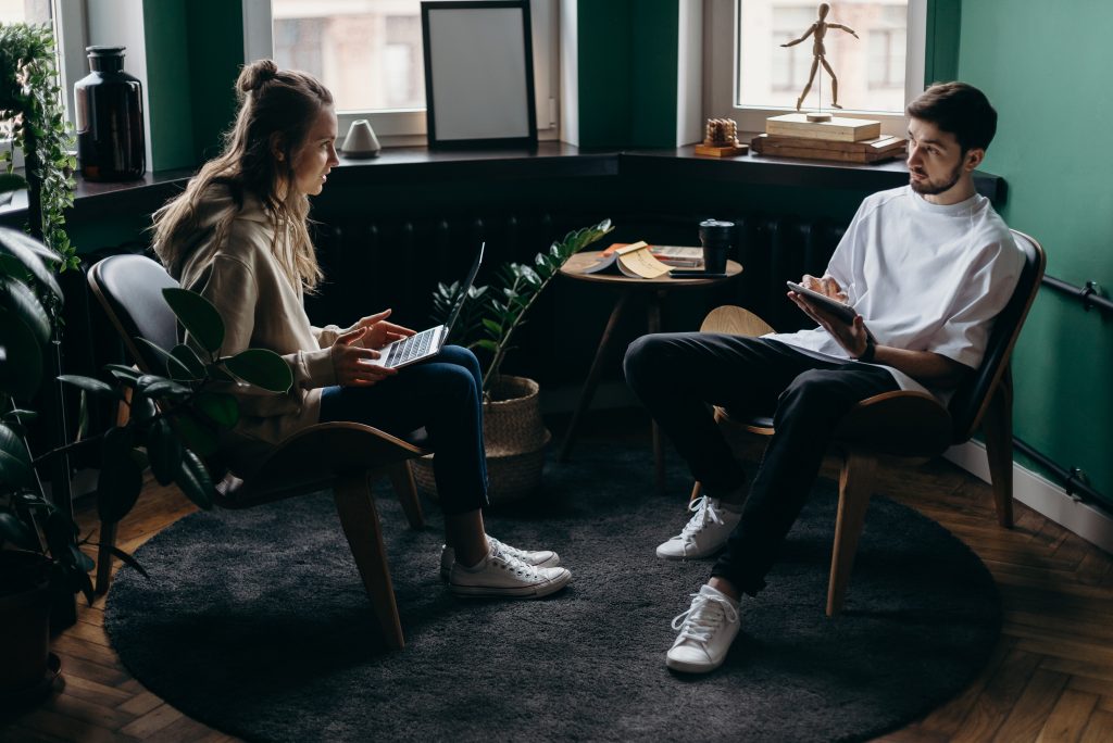un homme et une femme sont assis avec un ordinateur à la main