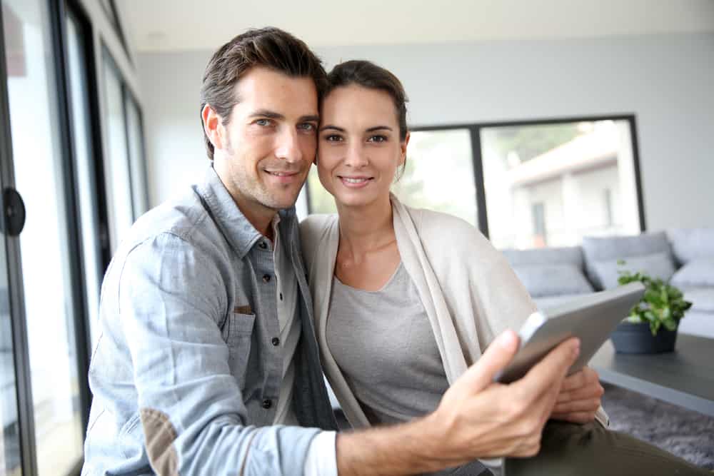 un homme et une femme sont assis côte à côte et tiennent un téléphone à la main