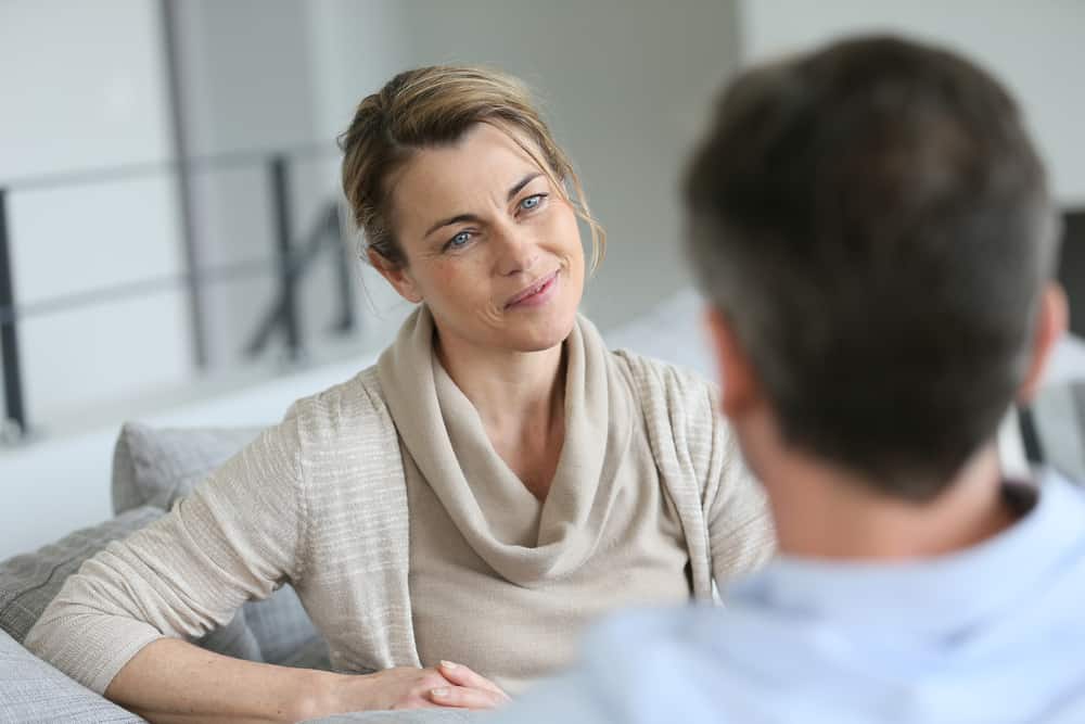 un homme et une femme sont assis face à face et parlent
