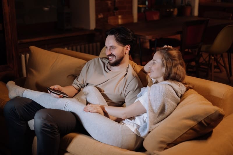 un homme et une femme sont assis sur le canapé