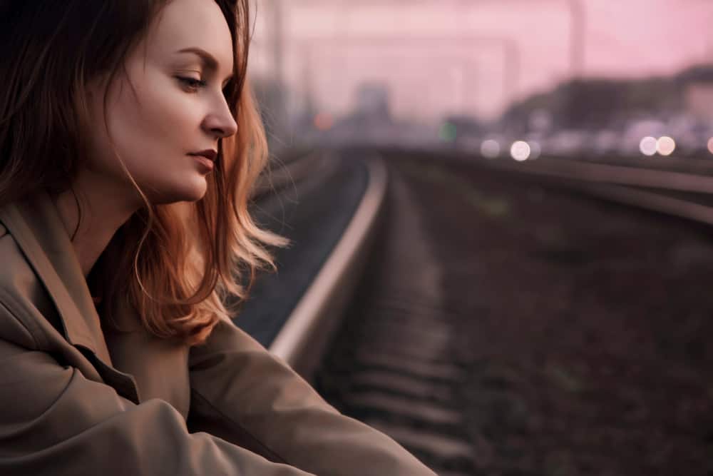une femme assise sur une voie ferrée
