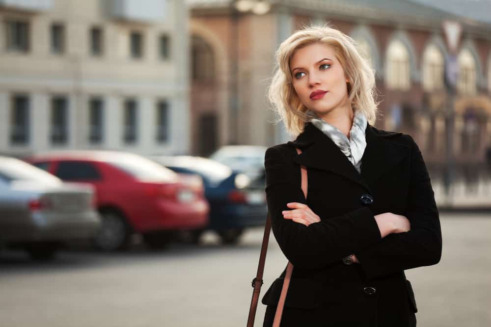 une femme aux cheveux blonds se tient dans la rue