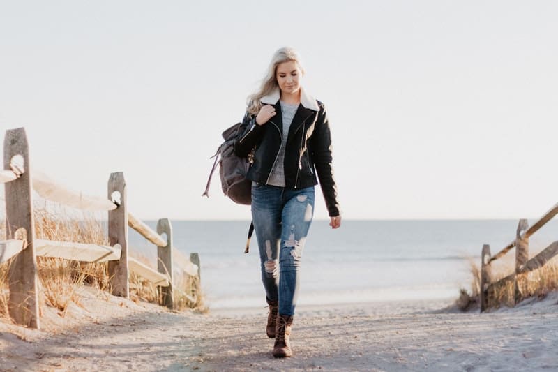 une femme avec un sac à dos marche dans la rue