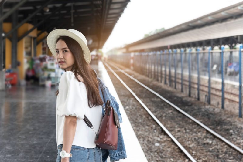 une femme debout à la gare