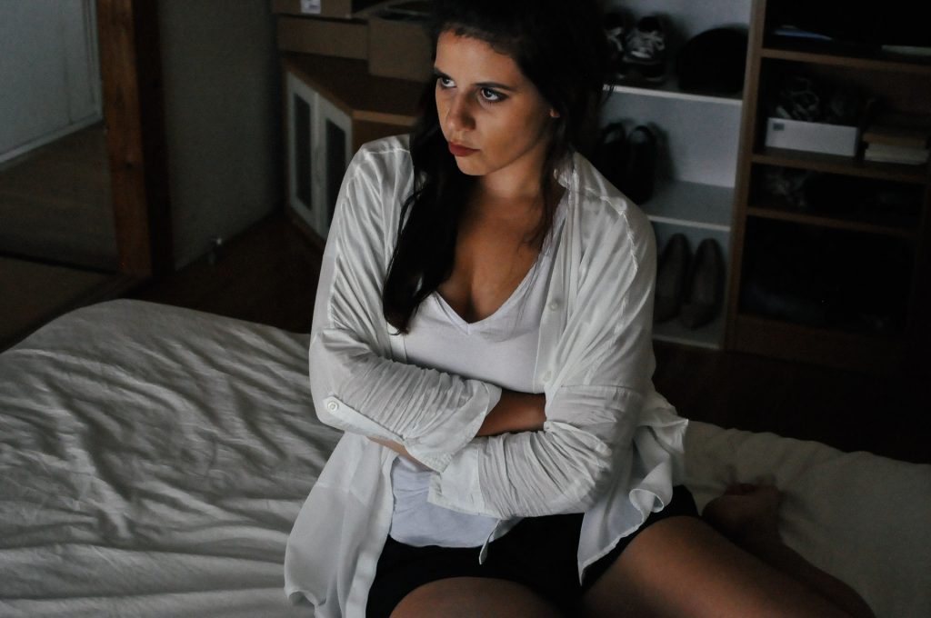 une femme en colère est assise sur le lit
