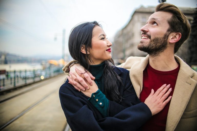 un homme et une femme se promènent en embrassant