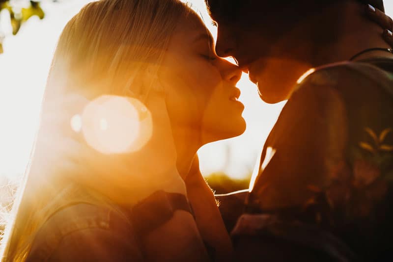 jeune couple, baiser, dans, coucher soleil