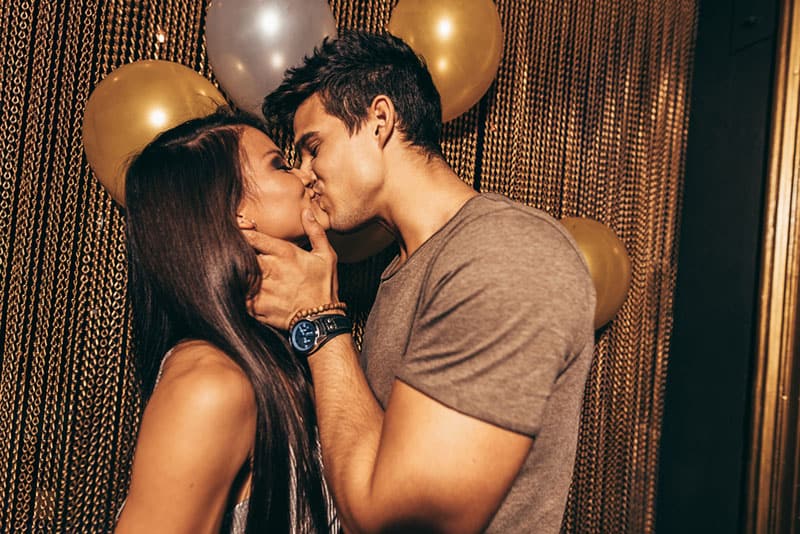 jeune couple s'embrassant dans la fête d'anniversaire