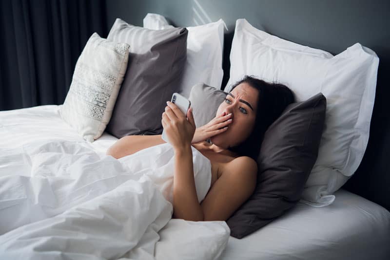 jeune femme choquée de voir une photo sur son téléphone