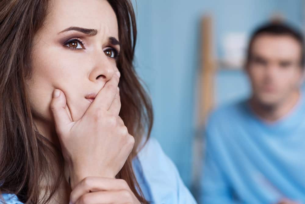 la femme se tient derrière l'homme et pense