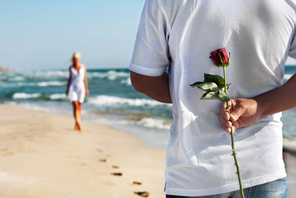 un homme a acheté une femme une rose sur la plage