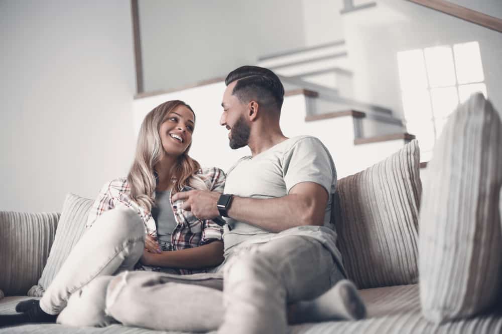 un homme et une femme parlant sur le canapé