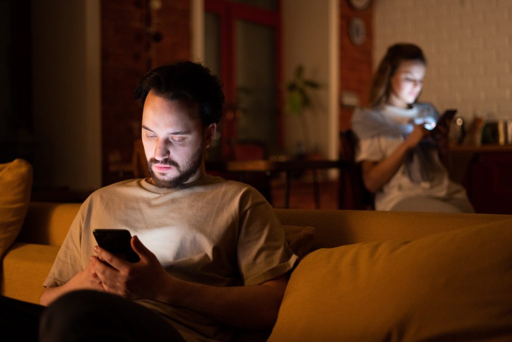un homme et une femme s'asseoir et taper sur le téléphone