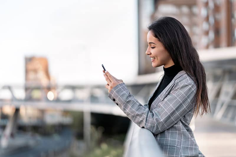 jeune brune au téléphone à l'extérieur