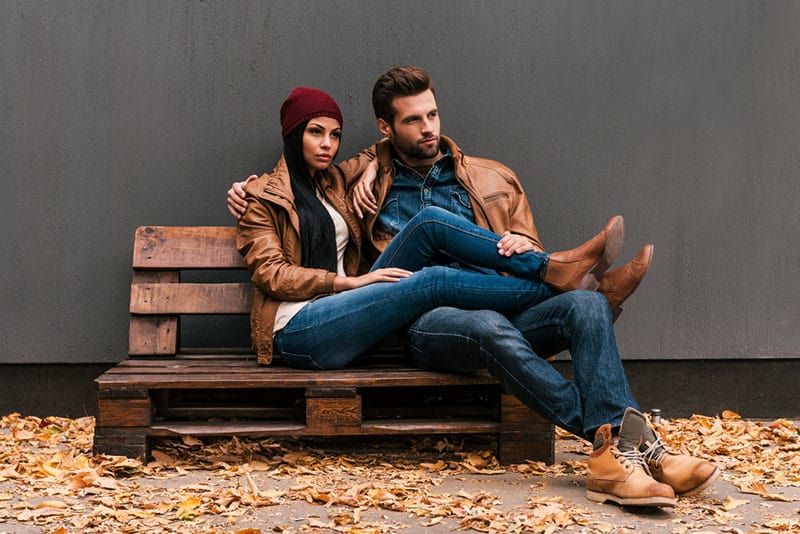 jeune homme et femme amis assis sur un banc
