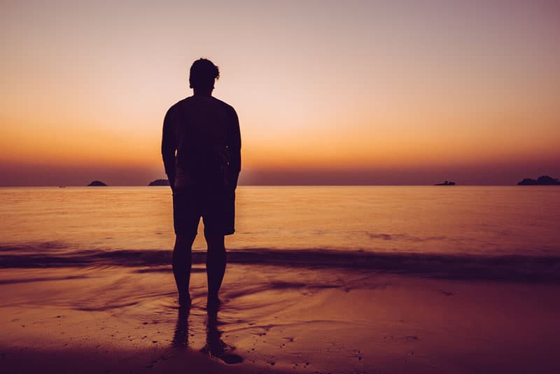 silhouette d'un jeune homme triste sur la plage